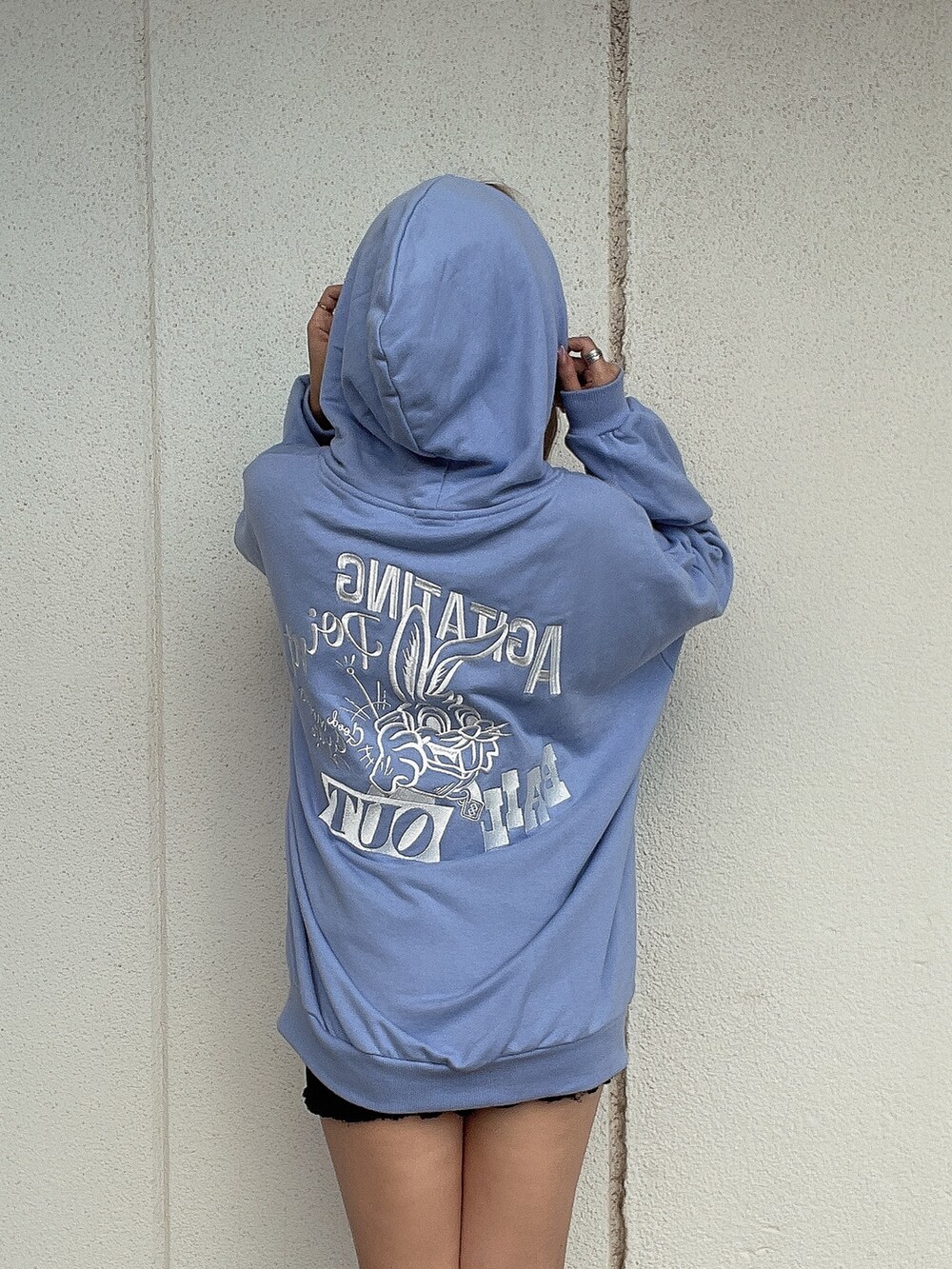 ブルー系のパーカー、ブラック系のブーツを着用したレディースの秋コーディネートの5枚目の写真