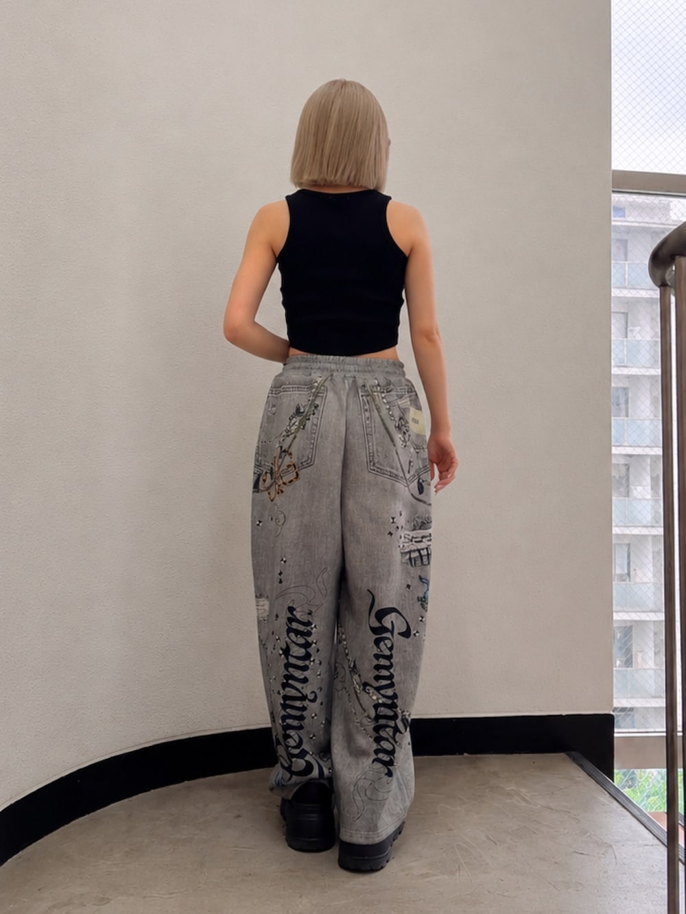 ブラック系のタンクトップ、ブラック系のデニムパンツ、ブラック系のスニーカーを着用したレディースの夏コーディネートの3枚目の写真