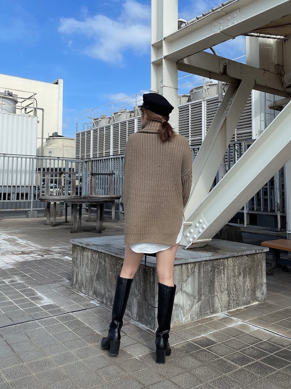 ブラック系のブーツ、ブラック系のデニムパンツ、ベージュ系のニット/セーターを着用したレディースの秋コーディネートの5枚目の写真