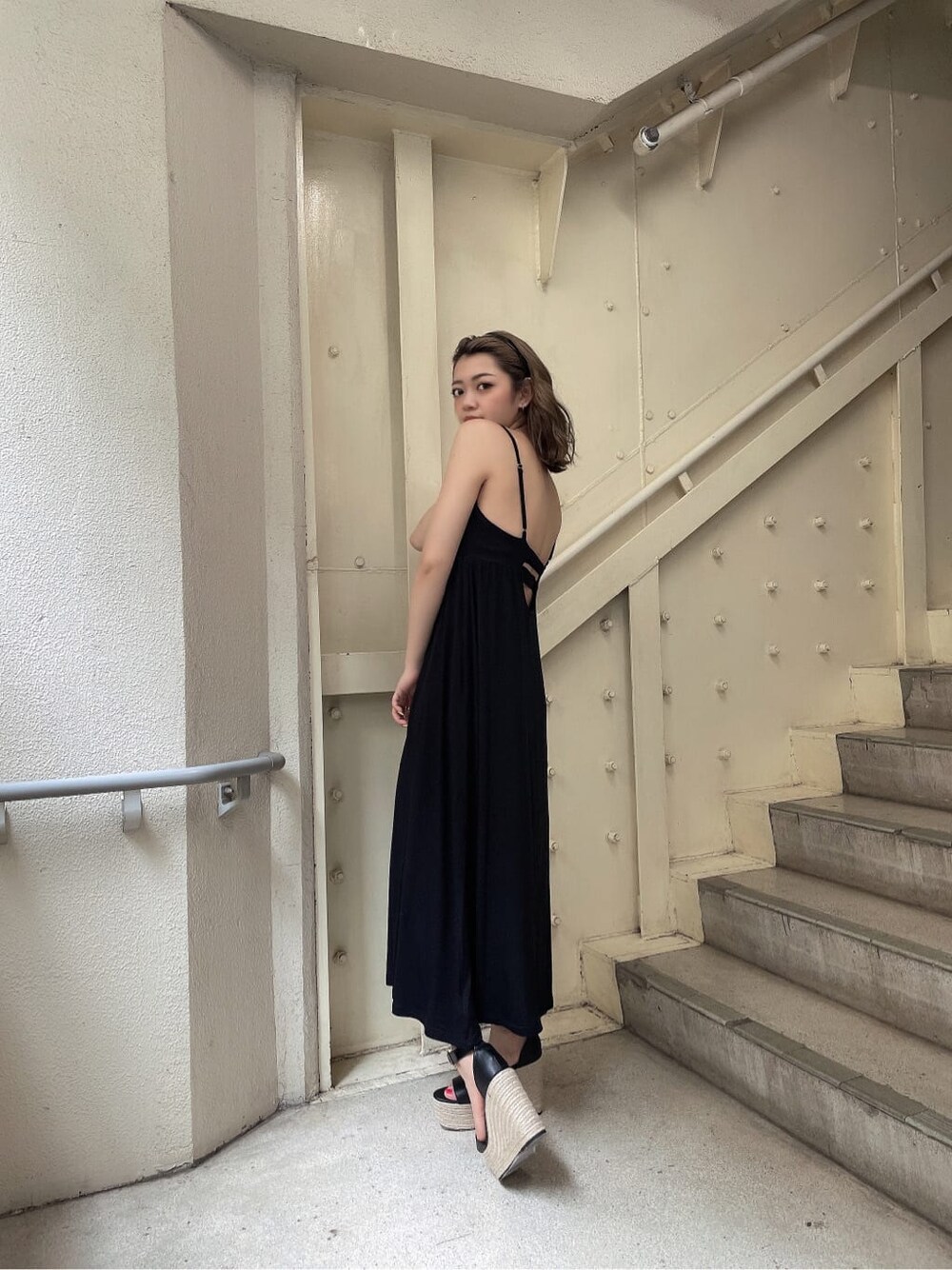 ブラック系のサンダル、ブラック系のワンピース、ホワイト系のTシャツ/カットソーを着用したレディースの夏コーディネートの3枚目の写真