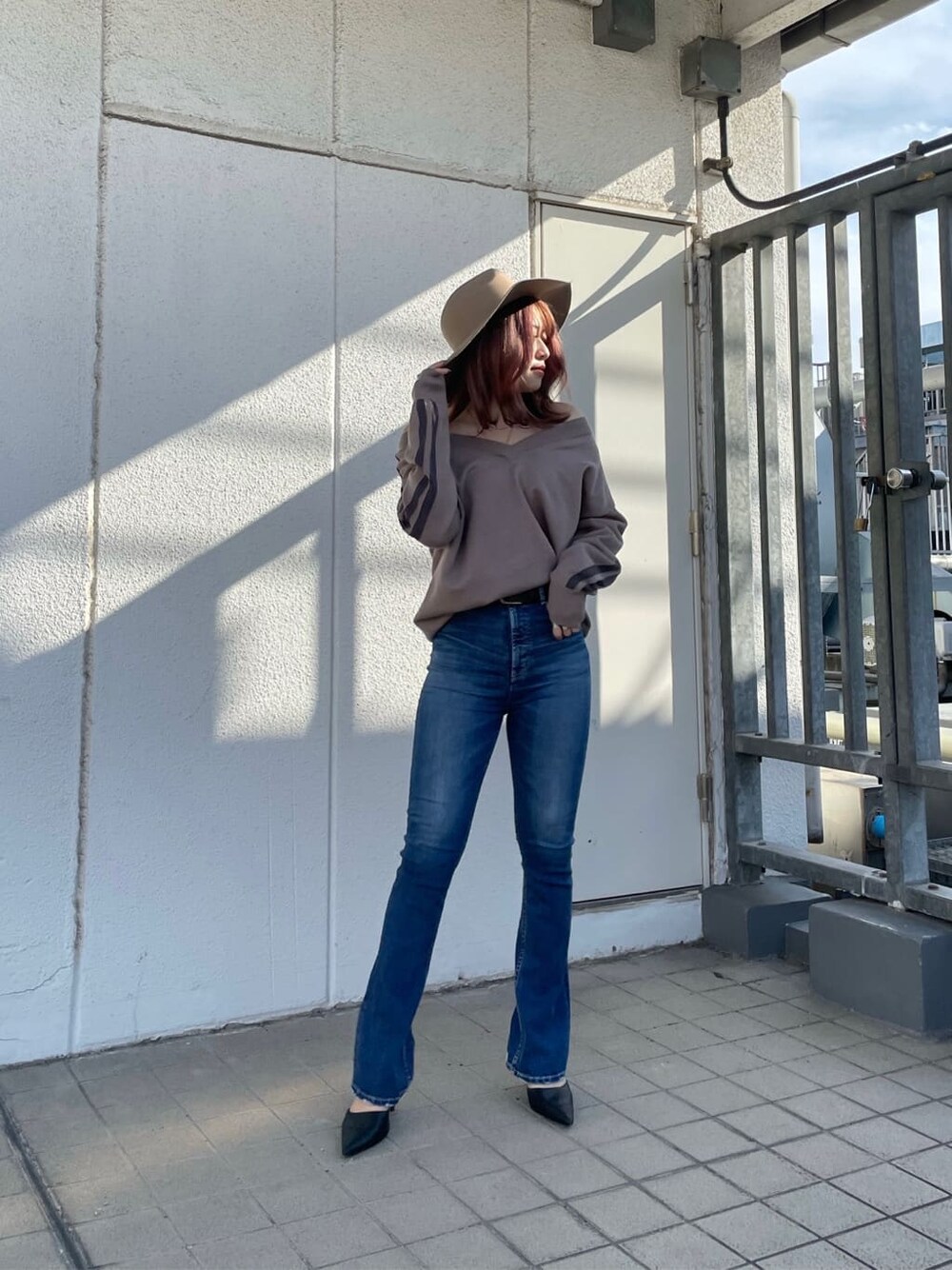 ブラック系のパンプス、ブルー系のデニムパンツ、ベージュ系のニット/セーターを着用したレディースの冬コーディネートの4枚目の写真