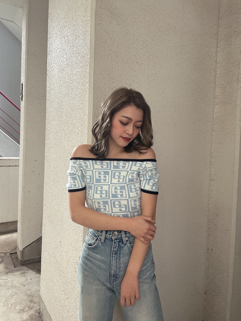 ブルー系のニット/セーター、ブルー系のデニムパンツ、ブラック系のパンプスを着用したレディースの冬コーディネートの4枚目の写真