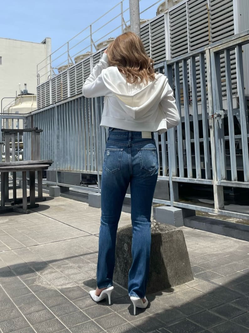 ホワイト系のパンプス、ブルー系のデニムパンツ、ホワイト系のパーカーを着用したレディースの夏コーディネートの6枚目の写真