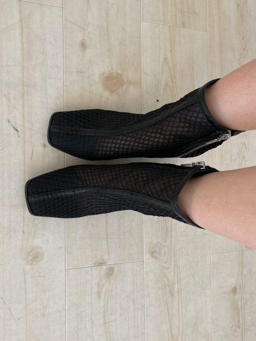 グレー系のスカート、ブラック系のブーツ、ブラック系のライダースジャケットを着用したレディースの冬コーディネートの9枚目の写真