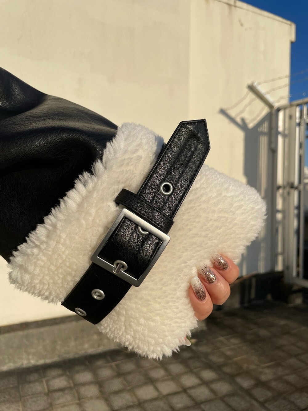 ホワイト系のブルゾン、ブラック系のブーツを着用したレディースの秋コーディネートの6枚目の写真