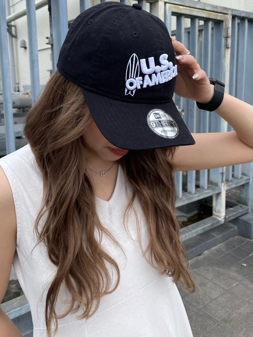 ホワイト系のワンピース、ブラック系のキャップを着用したレディースの春コーディネートの6枚目の写真