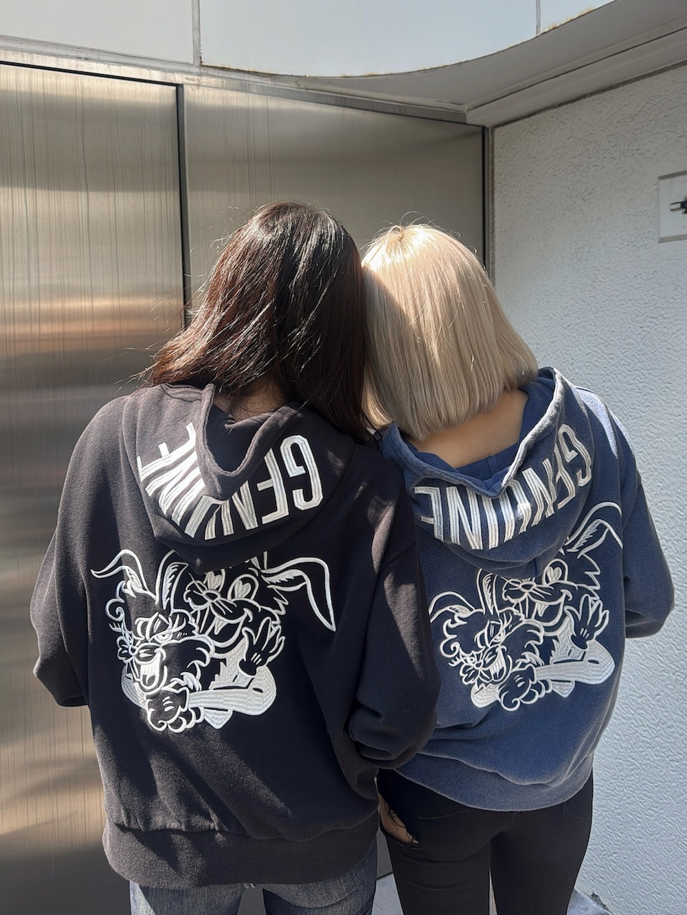 ブルー系のパーカー、ブラック系のパーカー、ブルー系のデニムパンツを着用したレディースの秋コーディネートの3枚目の写真