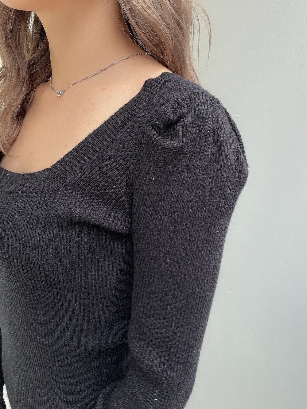 ブラック系のワンピース、ブラック系のハンドバッグ、ブラック系のパンプスを着用したレディースの秋コーディネートの6枚目の写真