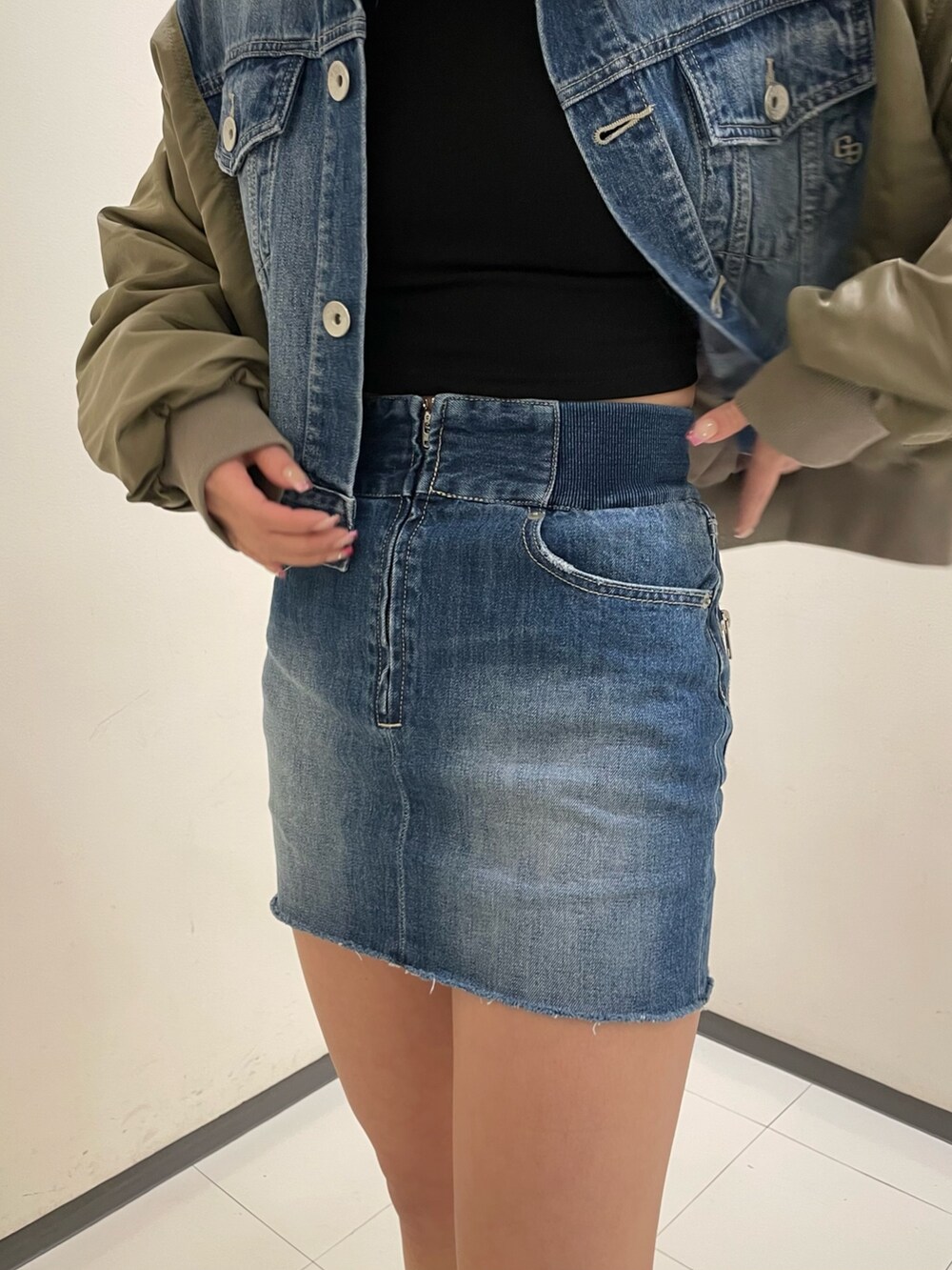 ブルー系のデニムスカート、ブラック系のブーツ、ブラック系のTシャツ/カットソーを着用したレディースの冬コーディネートの8枚目の写真