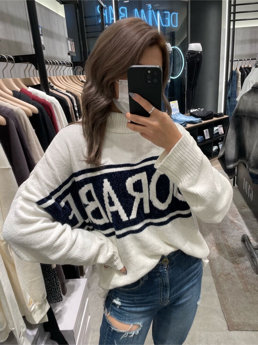 ホワイト系のニット/セーター、ホワイト系のパンプス、ブルー系のデニムパンツを着用したレディースの秋コーディネートの3枚目の写真