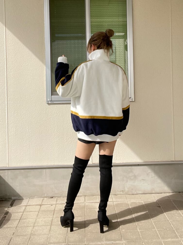 ホワイト系のブルゾン、ブラック系のブーツを着用したレディースの秋コーディネートの2枚目の写真