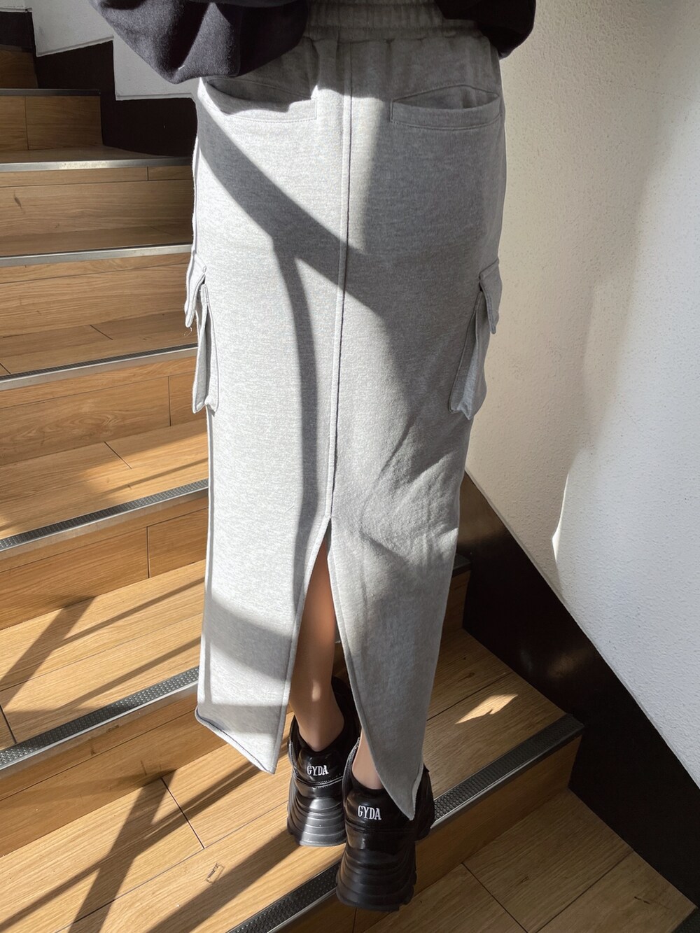 ブラック系のパーカー、グレー系のスカート、ブラック系のスニーカーを着用したレディースの冬コーディネートの6枚目の写真