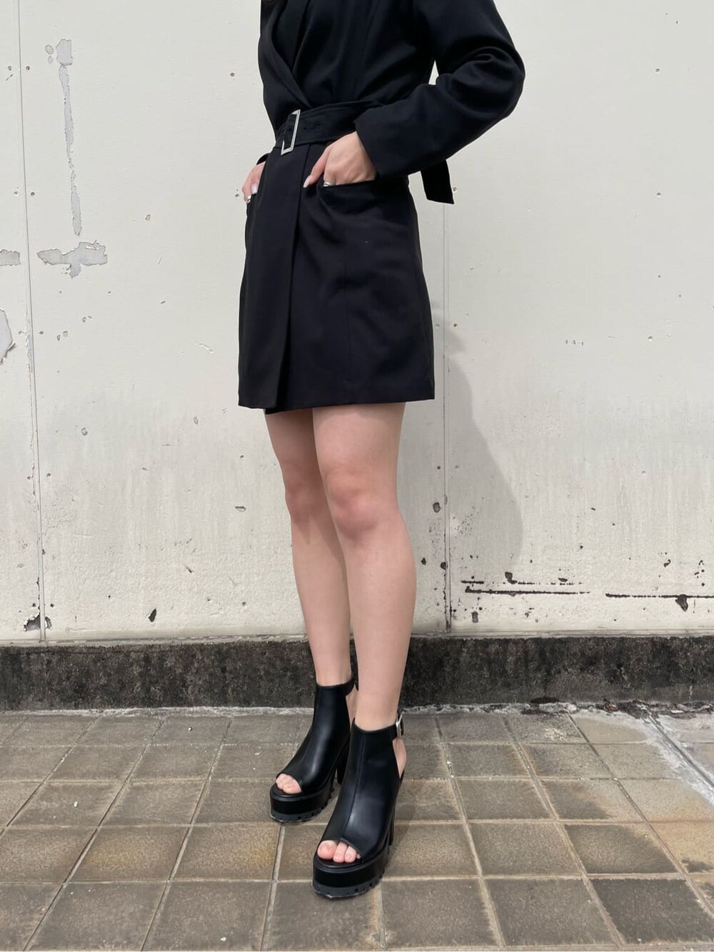 ブラック系のキャミソール、ブラック系のワンピース、ブラック系のブーツを着用したレディースの春コーディネートの5枚目の写真