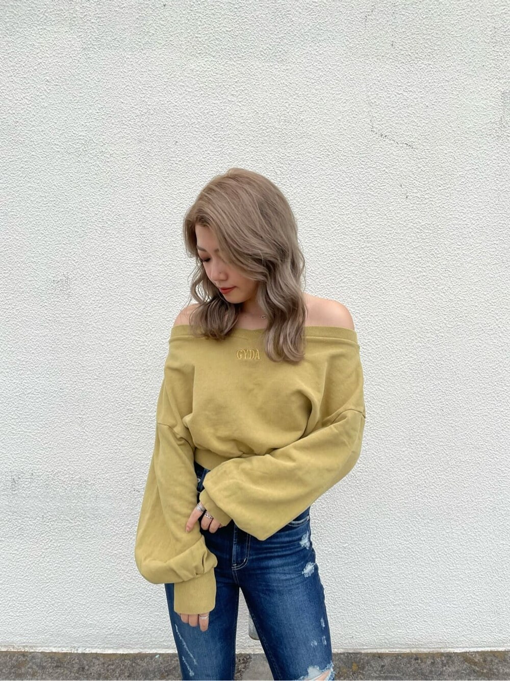 ブラック系のパンプス、イエロー系のスウェット、ブルー系のデニムパンツを着用したレディースの夏コーディネートの3枚目の写真