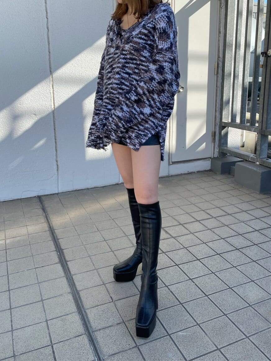 グレー系のニット/セーター、ブラック系のスカート、ブラック系のブーツを着用したレディースの秋コーディネートの5枚目の写真