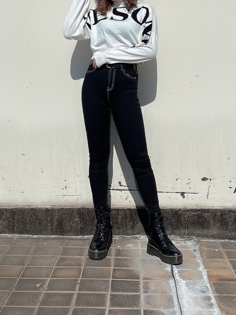 ホワイト系のニット/セーター、ブラック系のデニムパンツ、ブラック系のブーツを着用したレディースの秋コーディネートの3枚目の写真