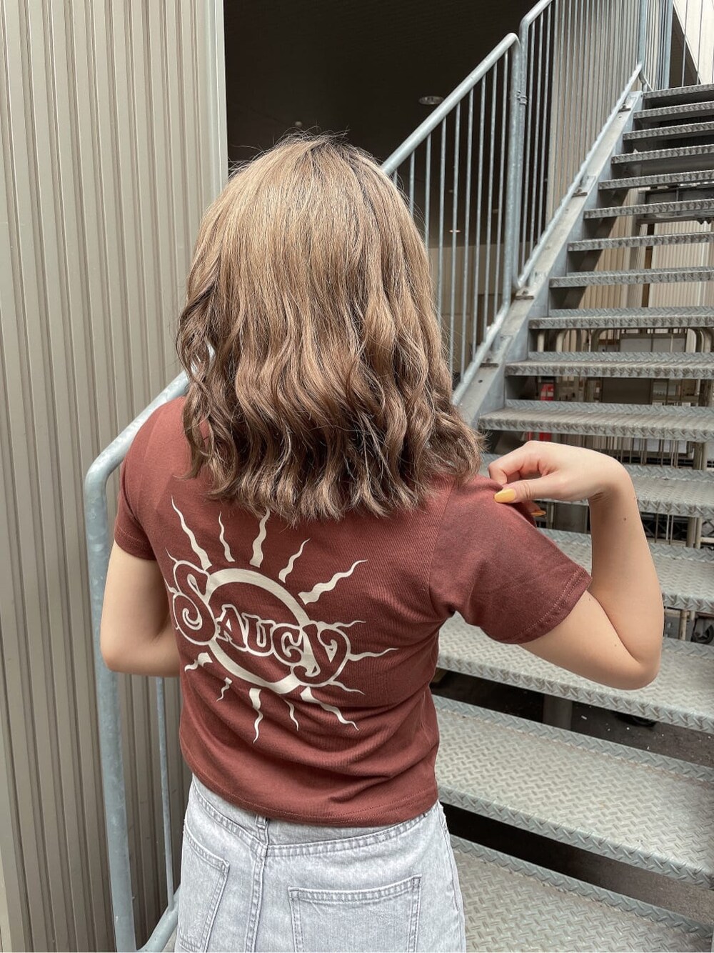 ベージュ系のサンダル、ブラウン系のTシャツ/カットソー、グレー系のデニムスカートを着用したレディースの夏コーディネートの2枚目の写真