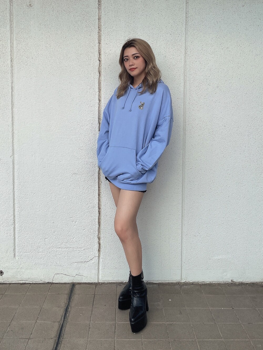 ブルー系のパーカー、ブラック系のブーツを着用したレディースの秋コーディネートの4枚目の写真