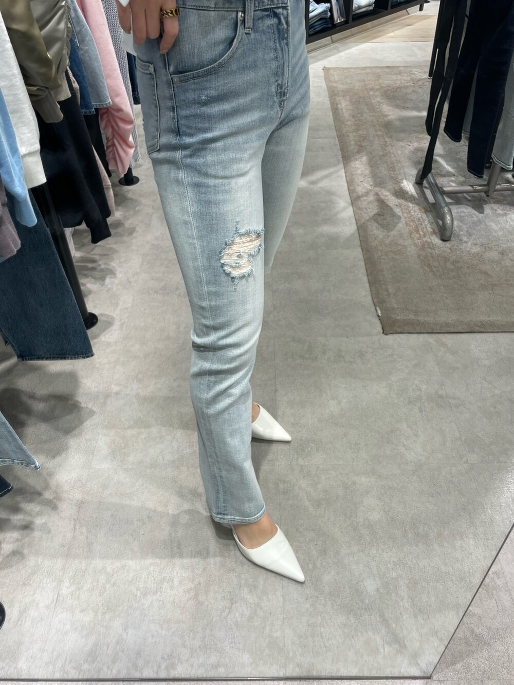 ホワイト系のシャツ/ブラウス、ブルー系のデニムパンツ、ホワイト系のパンプスを着用したレディースの冬コーディネートの7枚目の写真