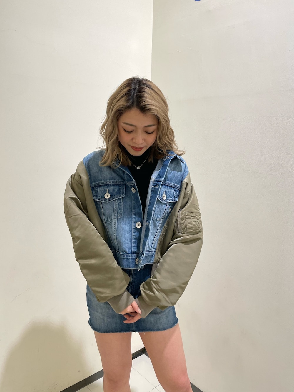 ブルー系のデニムスカート、ブラック系のブーツ、ブラック系のTシャツ/カットソーを着用したレディースの冬コーディネートの4枚目の写真