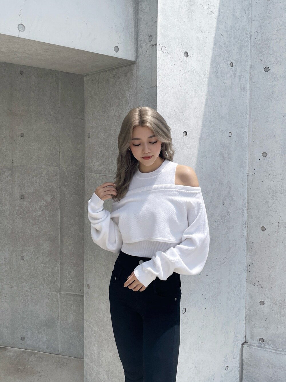 ホワイト系のアンサンブル、ブラック系のデニムパンツ、ブラック系のパンプスを着用したレディースの秋コーディネートの3枚目の写真