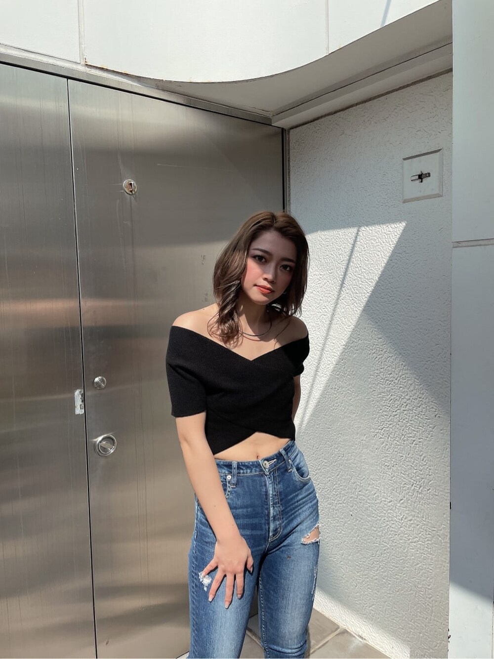 ブラック系のパンプス、ブルー系のデニムパンツ、ブラック系のニット/セーターを着用したレディースの春コーディネートの3枚目の写真