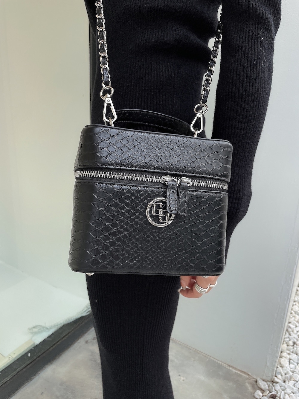 ブラック系のワンピース、ブラック系のハンドバッグ、ブラック系のパンプスを着用したレディースの秋コーディネートの7枚目の写真