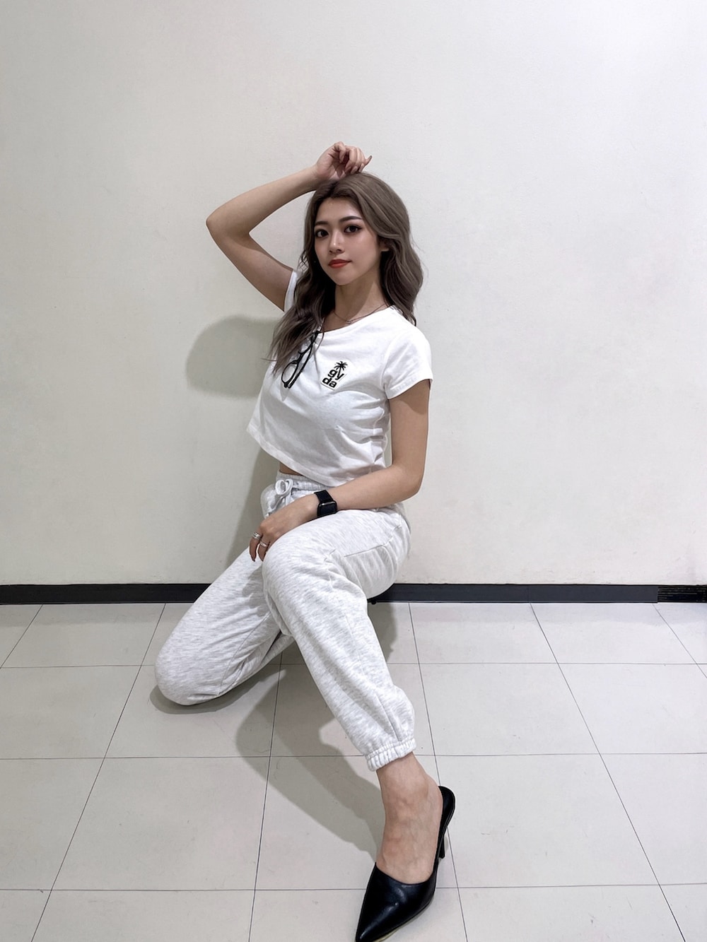 ホワイト系のTシャツ/カットソー、グレー系のスウェットパンツ、ブラック系のパンプスを着用したレディースの夏コーディネートの3枚目の写真