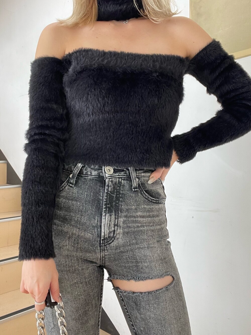 ブラック系のニット/セーター、ブラック系のデニムパンツ、ブラック系のブーツを着用したレディースの秋コーディネートの4枚目の写真