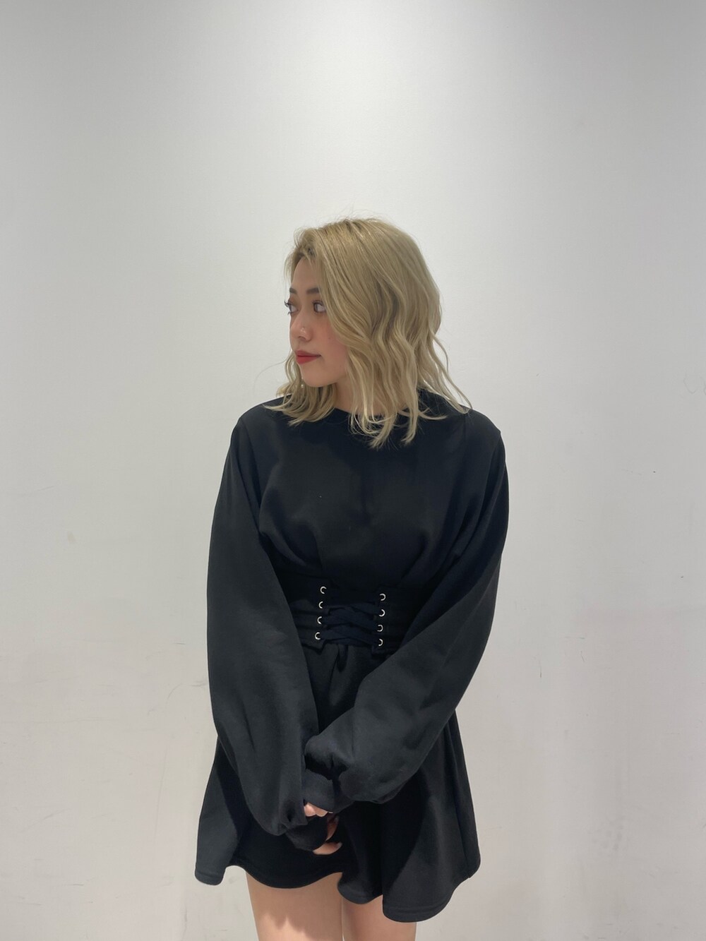 ブラック系のワンピース、ブラック系のブーツ、ホワイト系のダウンジャケット/コートを着用したレディースの冬コーディネートの6枚目の写真