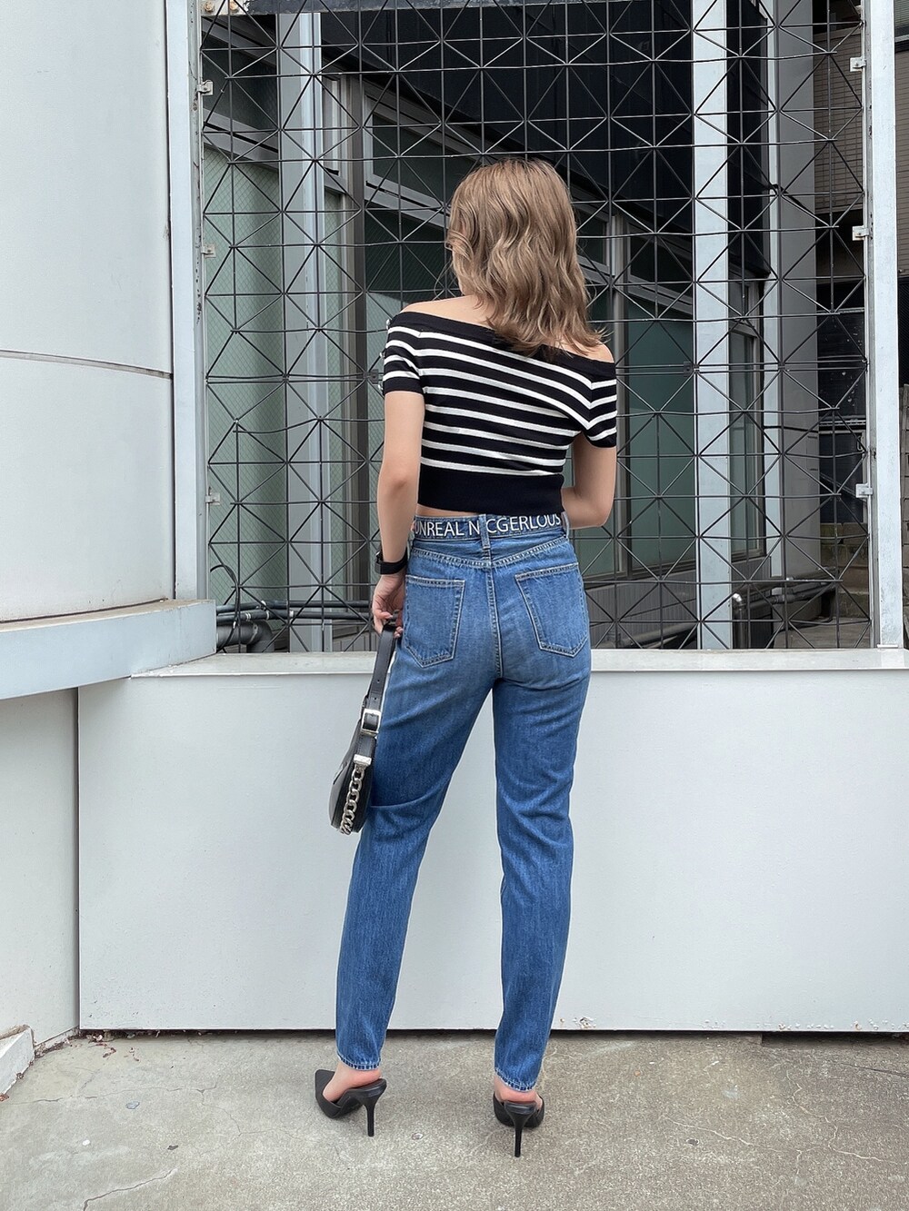 その他のニット/セーター、ブルー系のデニムパンツ、ブラック系のパンプスを着用したレディースの春コーディネートの3枚目の写真