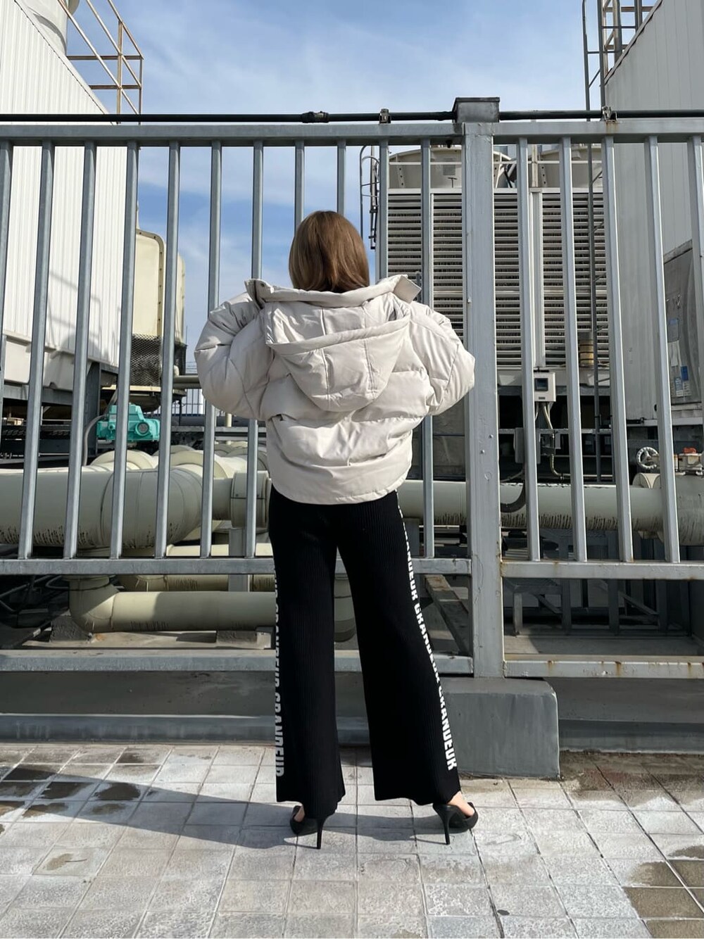 ブラック系のパンプス、ホワイト系のダウンジャケット/コート、ブラック系のその他パンツを着用したレディースの冬コーディネートの3枚目の写真