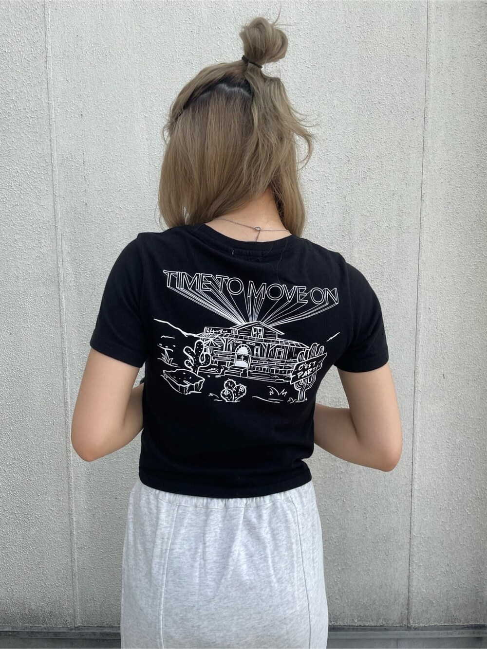 グレー系のスカート、ブラック系のTシャツ/カットソー、ブラック系の財布を着用したレディースの夏コーディネートの3枚目の写真