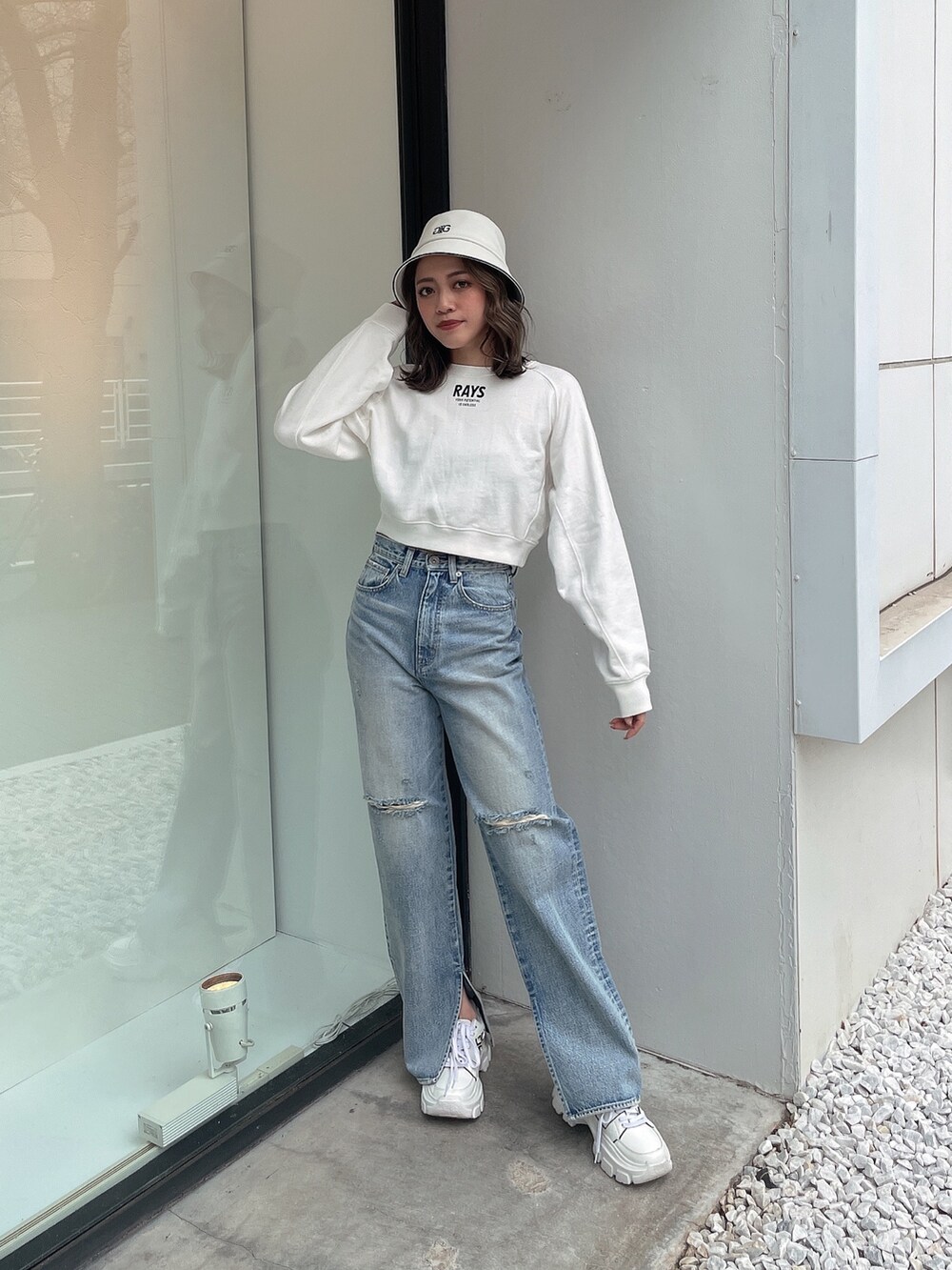 ホワイト系のスウェット、ブルー系のデニムパンツ、ホワイト系のスニーカーを着用したレディースの冬コーディネートの2枚目の写真