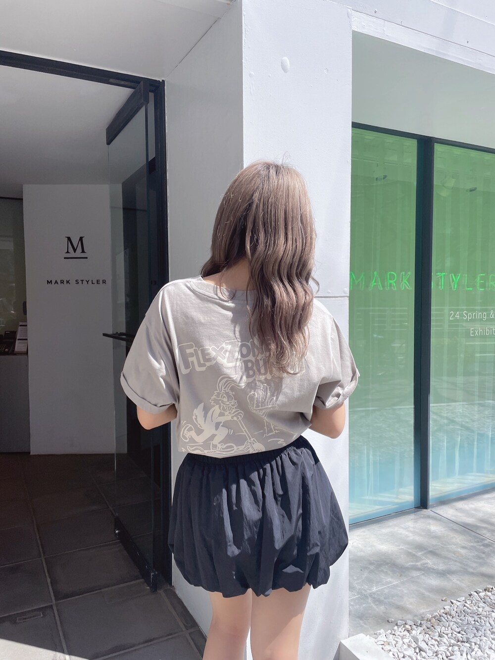 ベージュ系のTシャツ/カットソー、ブラック系のスカート、ブラック系のサンダルを着用したレディースの春コーディネートの3枚目の写真