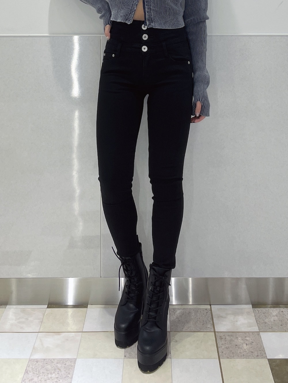 ブルー系のニット/セーター、ブラック系のデニムパンツ、ブラック系のブーツを着用したレディースの冬コーディネートの6枚目の写真