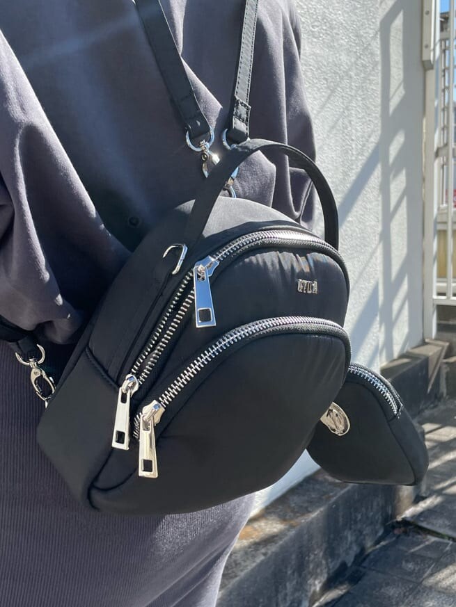 ブラック系のブーツ、ブラック系のバックパック/リュック、グレー系のワンピースを着用したレディースの冬コーディネートの4枚目の写真