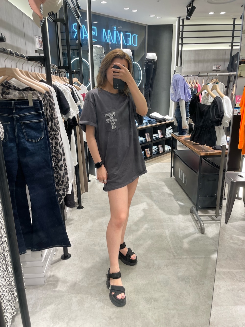 グレー系のTシャツ/カットソー、ブルー系のデニムパンツ、ブラック系のサンダルを着用したレディースの春コーディネートの3枚目の写真