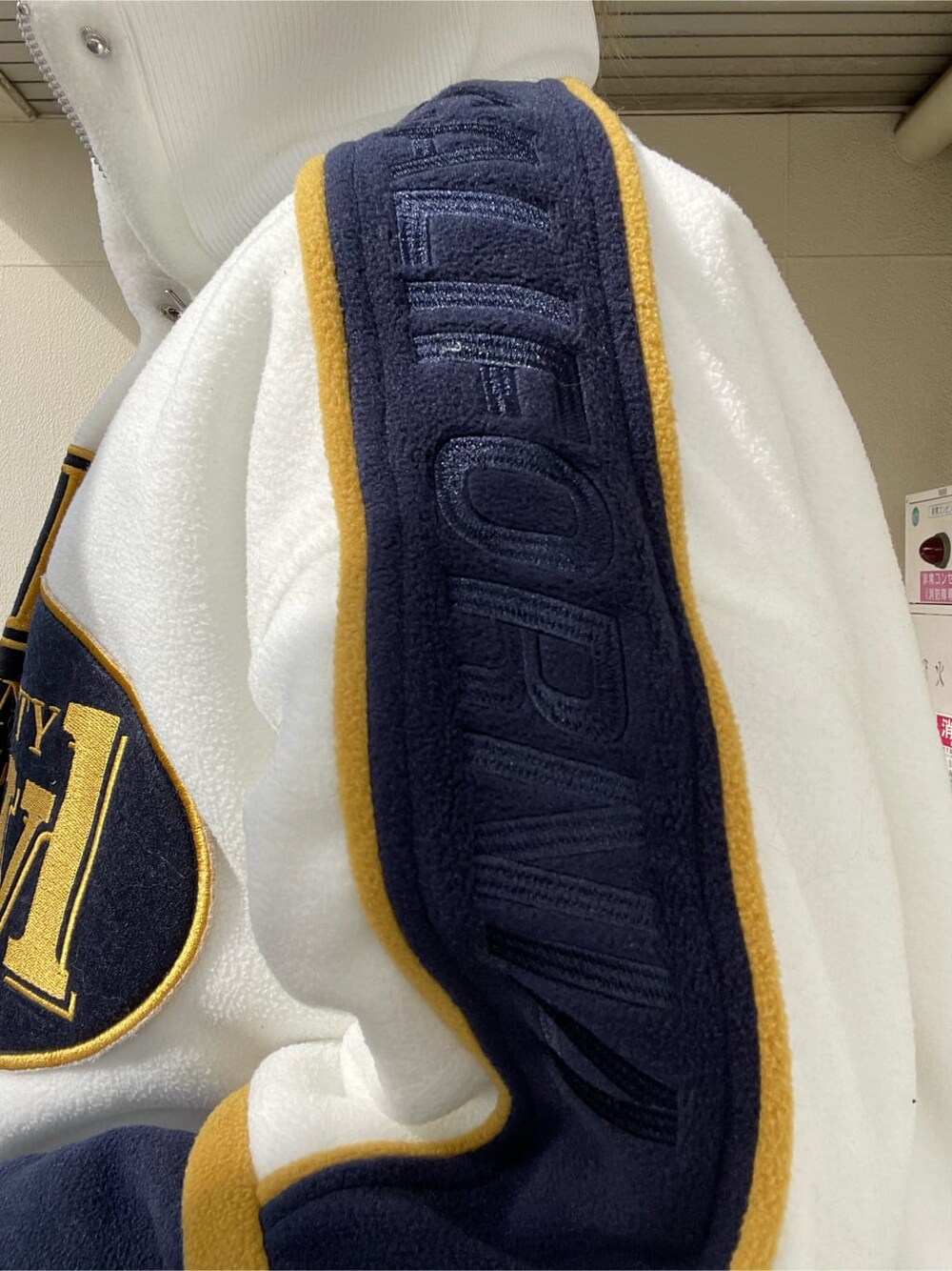 ホワイト系のブルゾン、ブラック系のブーツを着用したレディースの秋コーディネートの6枚目の写真