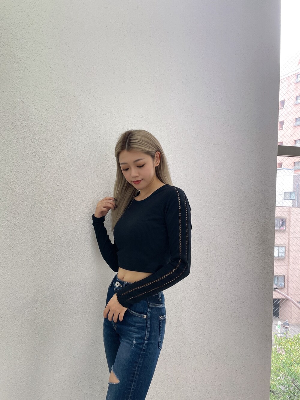 ブラック系のTシャツ/カットソー、ブルー系のデニムパンツ、ブラック系のブーツを着用したレディースの秋コーディネートの4枚目の写真