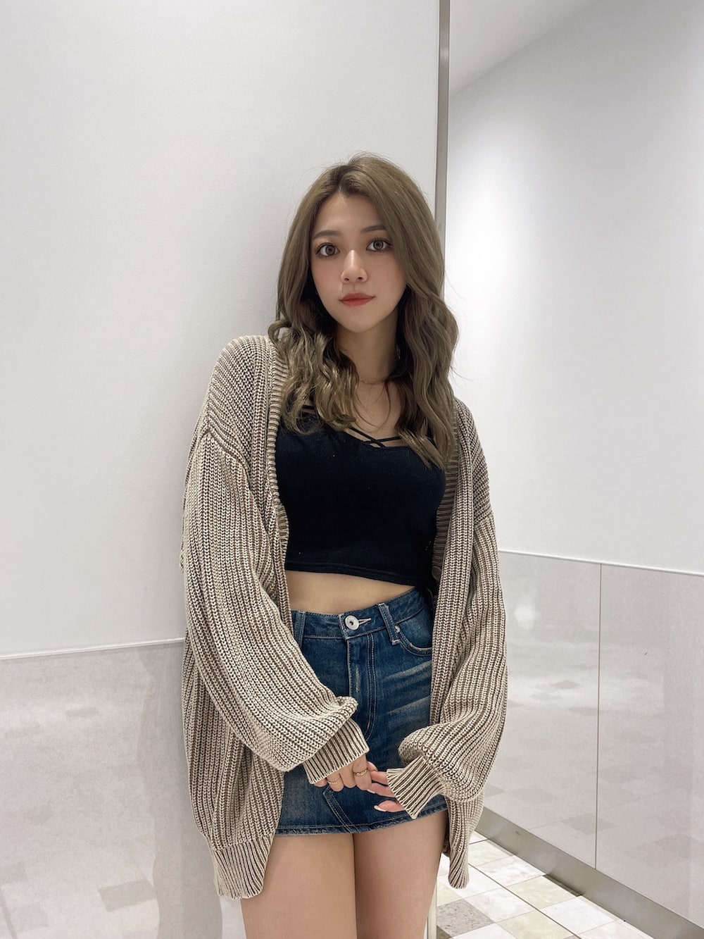 ブルー系のデニムスカート、ブラック系のブーツ、ベージュ系のカーディガン/ボレロを着用したレディースの夏コーディネートの4枚目の写真