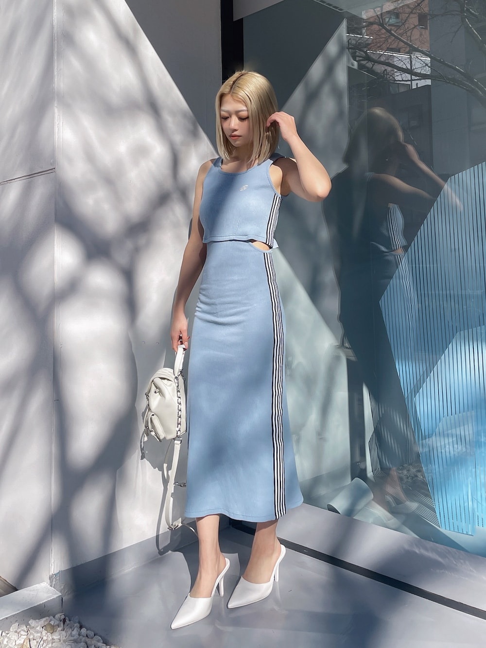 ブルー系のワンピース、ホワイト系のパンプス、ホワイト系のバックパック/リュックを着用したレディースの春コーディネートの2枚目の写真