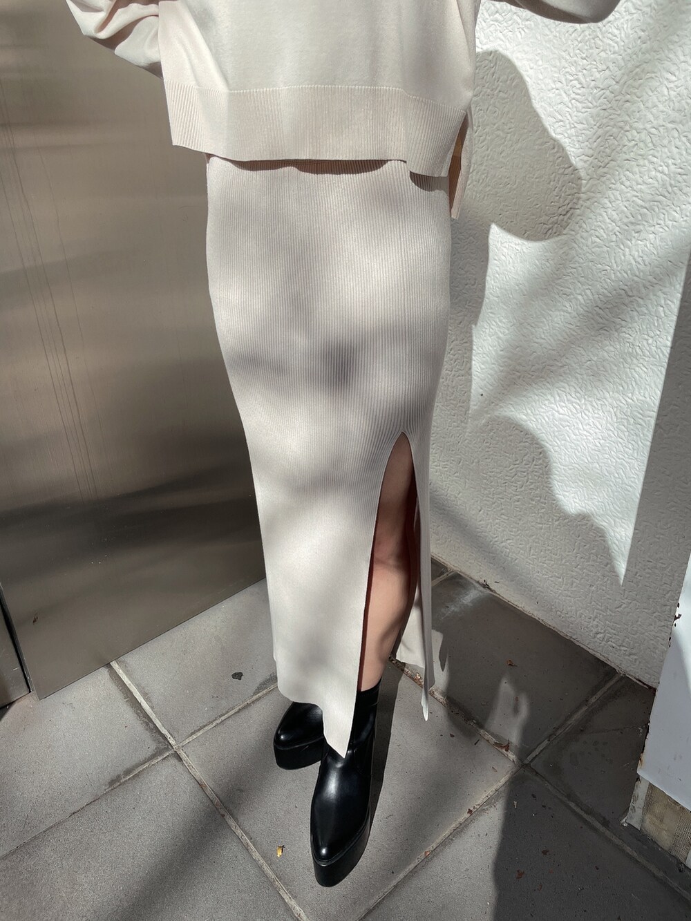 ホワイト系のニット/セーター、ホワイト系のスカート、ブラック系のブーツを着用したレディースの冬コーディネートの5枚目の写真