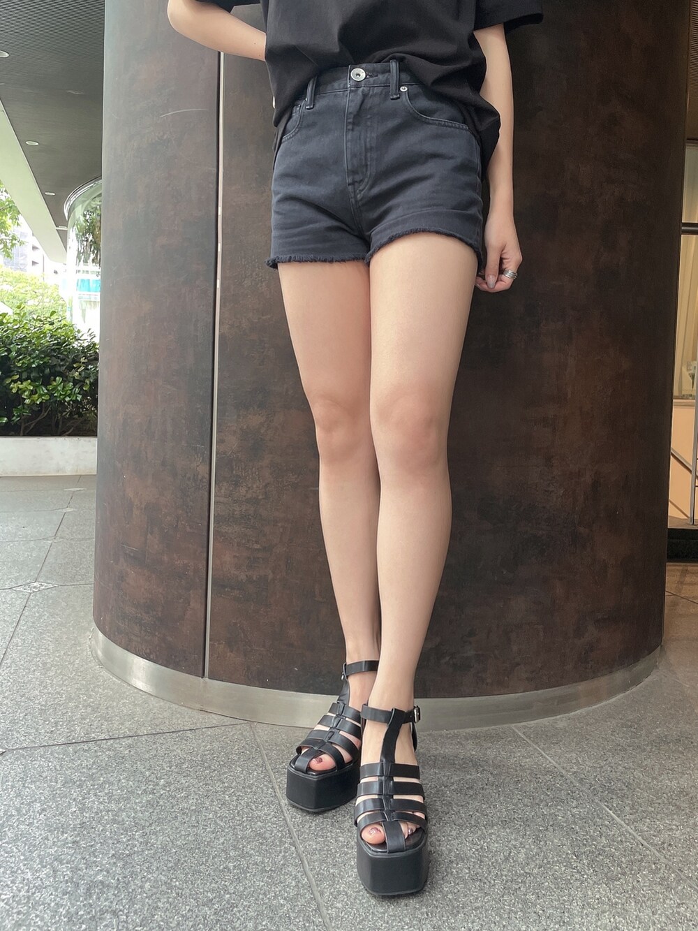 ブラック系のデニムパンツ、ブラック系のサンダル、ブラック系のTシャツ/カットソーを着用したレディースの夏コーディネートの6枚目の写真