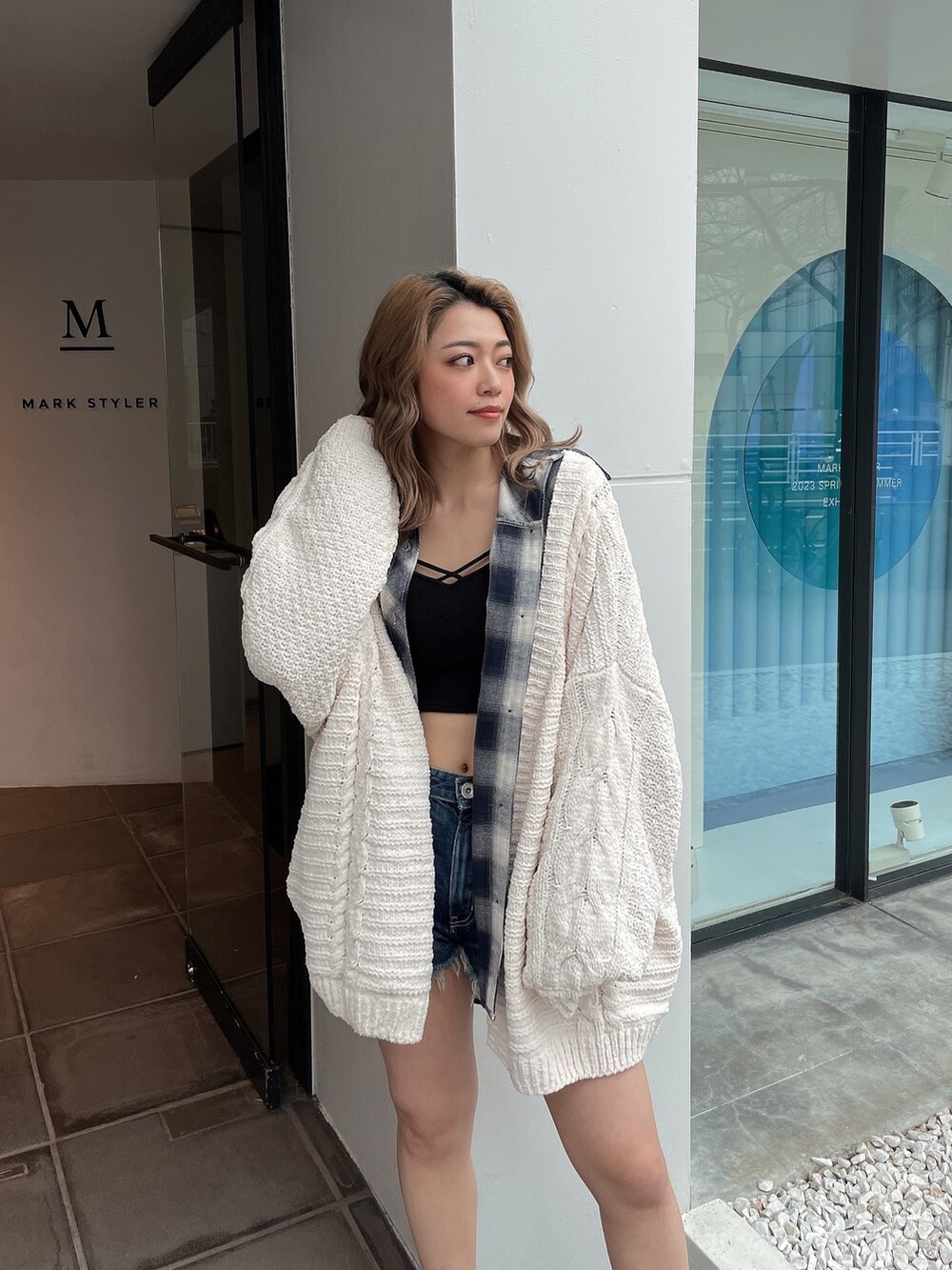 ホワイト系のカーディガン/ボレロ、ブルー系のシャツ/ブラウス、ブルー系のデニムパンツを着用したレディースの春コーディネートの4枚目の写真