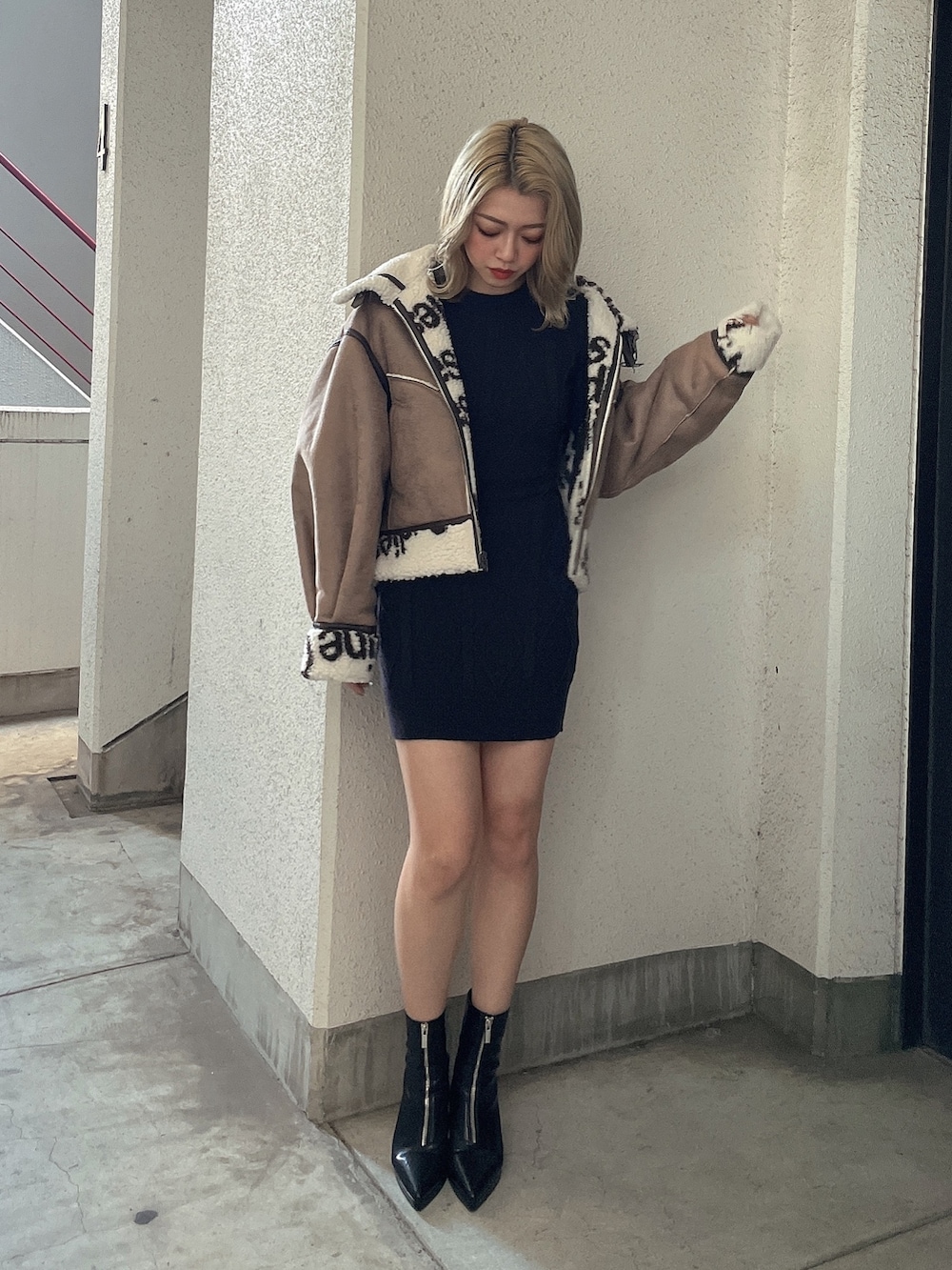 ブラック系のワンピース、ブラック系のブーツを着用したレディースの秋コーディネートの3枚目の写真