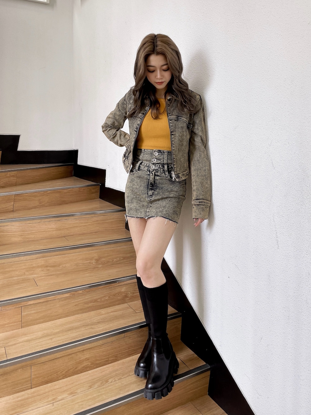 ブルー系のデニムスカート、イエロー系のタンクトップ、ブルー系のデニムジャケットを着用したレディースの秋コーディネートの3枚目の写真