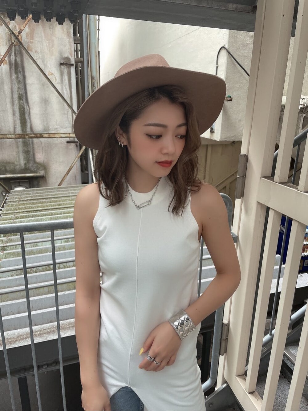 ホワイト系のニット/セーター、ブラック系のパンプス、ブルー系のデニムパンツを着用したレディースの夏コーディネートの5枚目の写真