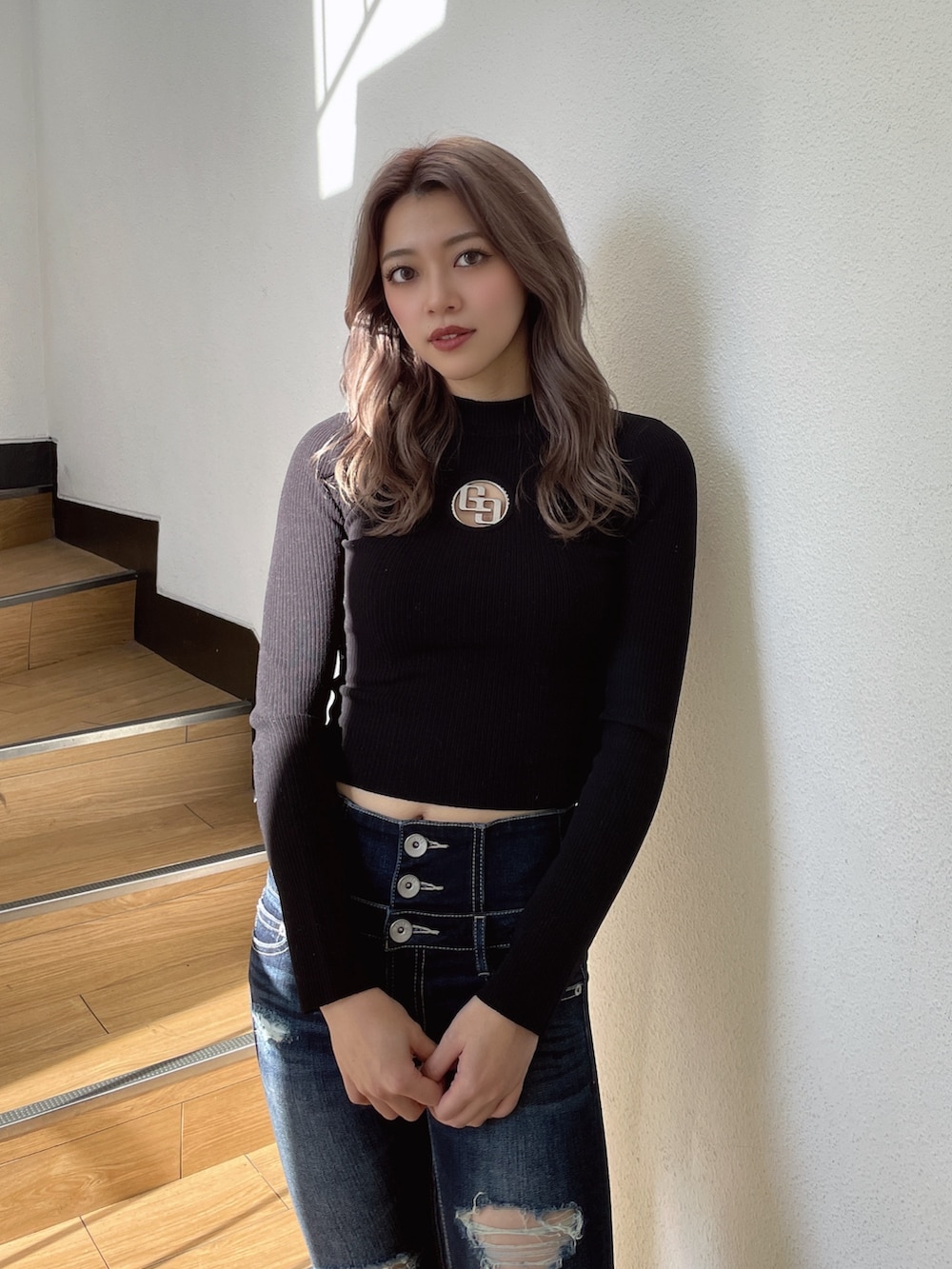 ブラック系のニット/セーター、ブラック系のパンプス、ブルー系のデニムパンツを着用したレディースの冬コーディネートの4枚目の写真