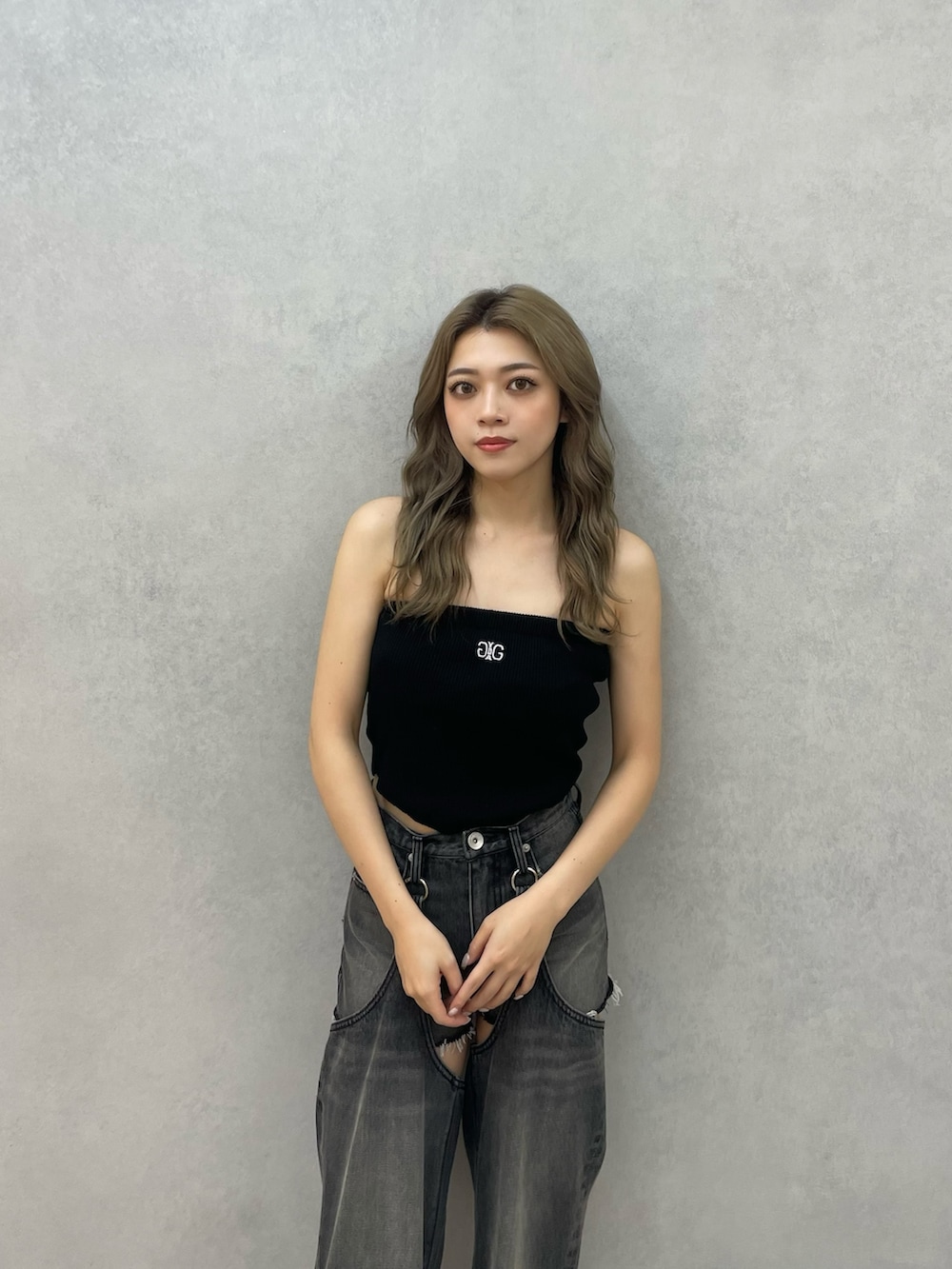 ブラック系のデニムパンツ、ブラック系のパンプス、ブラック系のチューブトップを着用したレディースの秋コーディネートの3枚目の写真